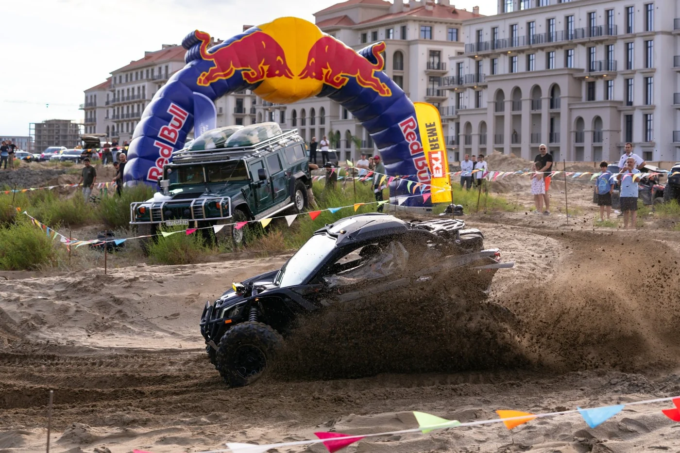A buggy kicks up sand by the inflatable start arch